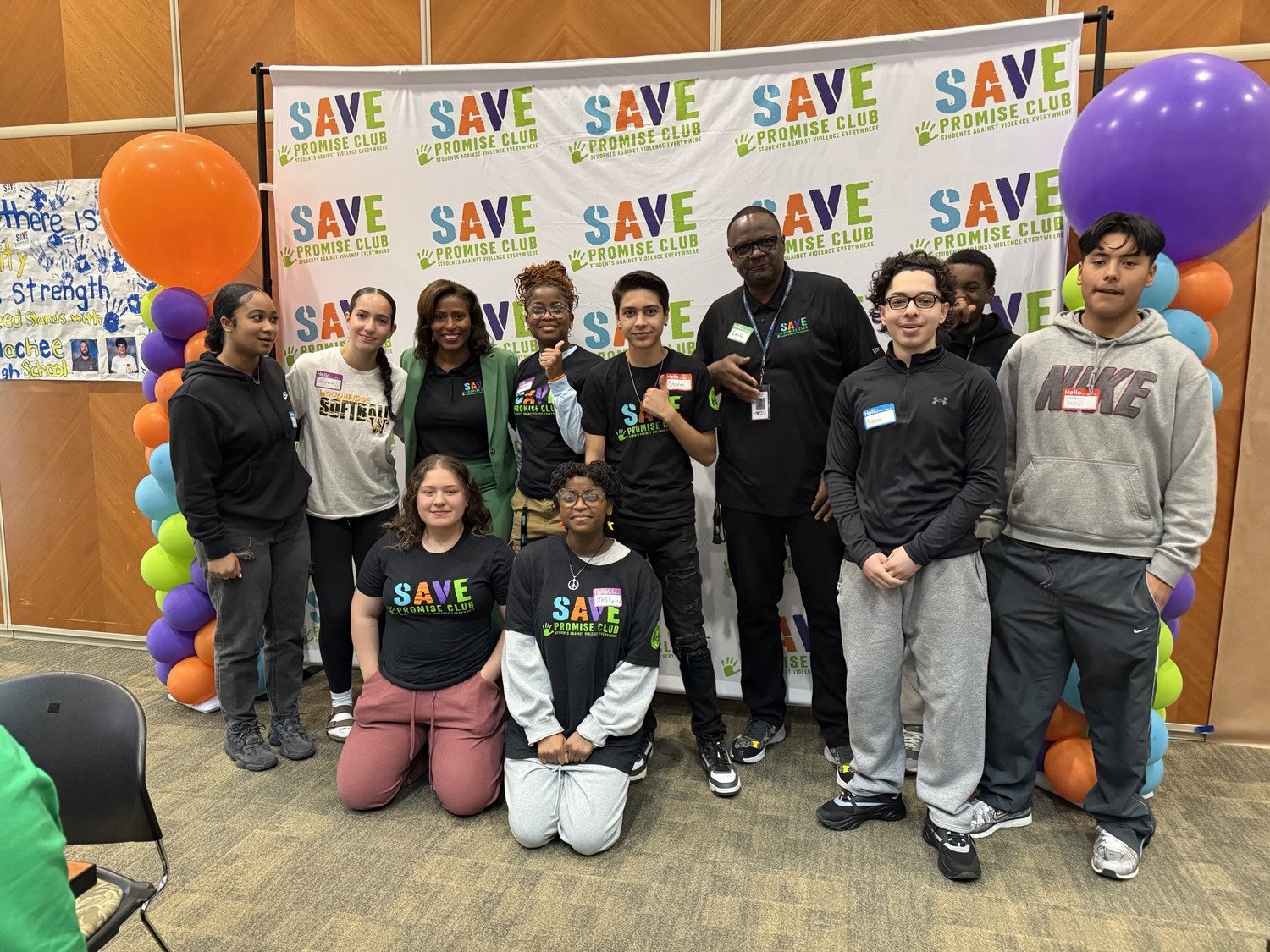 WSHS SAVE Club students, mentors along with Dr. McDade at the SAVE Promise Club event, standing in front of a colorful backdrop with balloons and the SAVE logo.