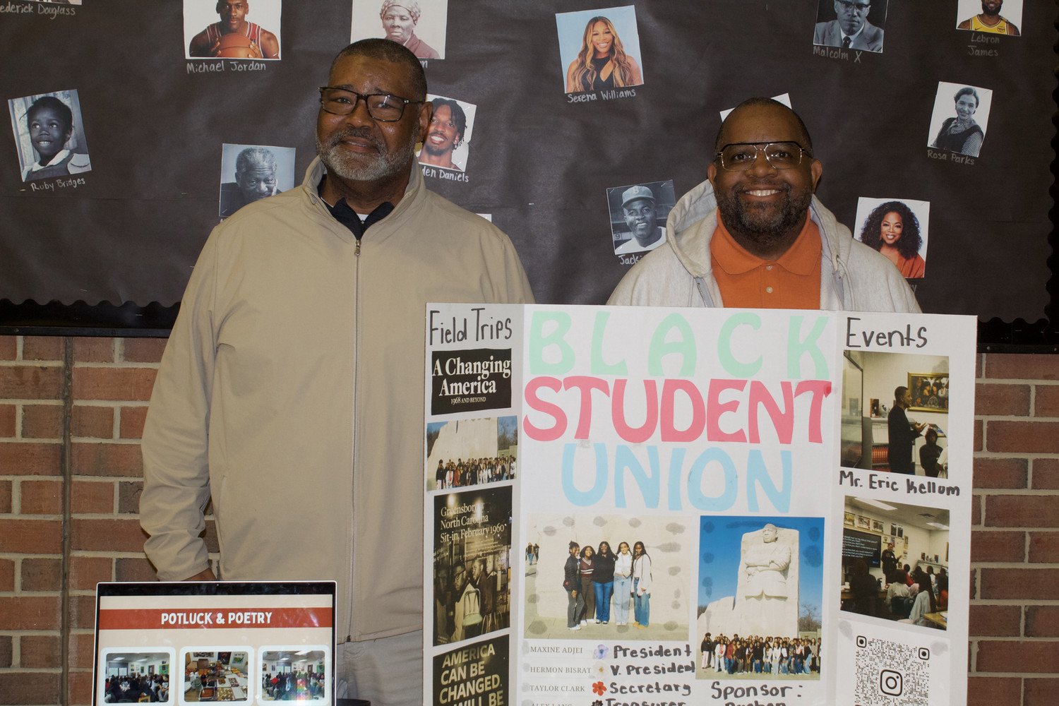 Two men standing next to a display board promoting the Black Student Union, featuring event details and a collage of images.
