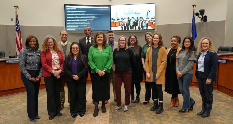 WSHS Staff and PWCS School Board poses together in a conference room, honoring their achievement of AP Honor Roll in the Bronze category in a formal setting.