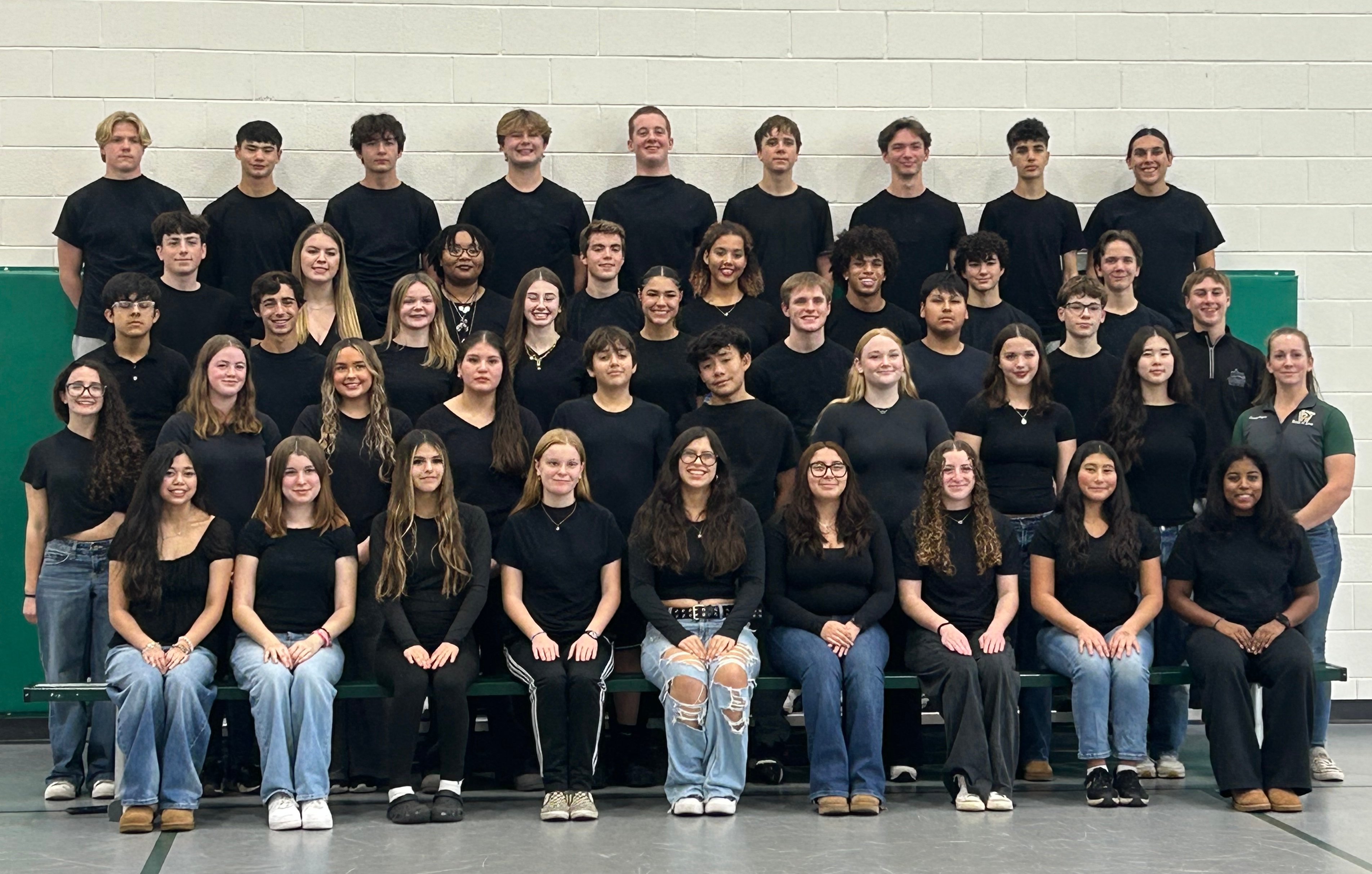 A group photo of 44 students in black shirts, arranged in a tiered formation in a gymnasium setting.